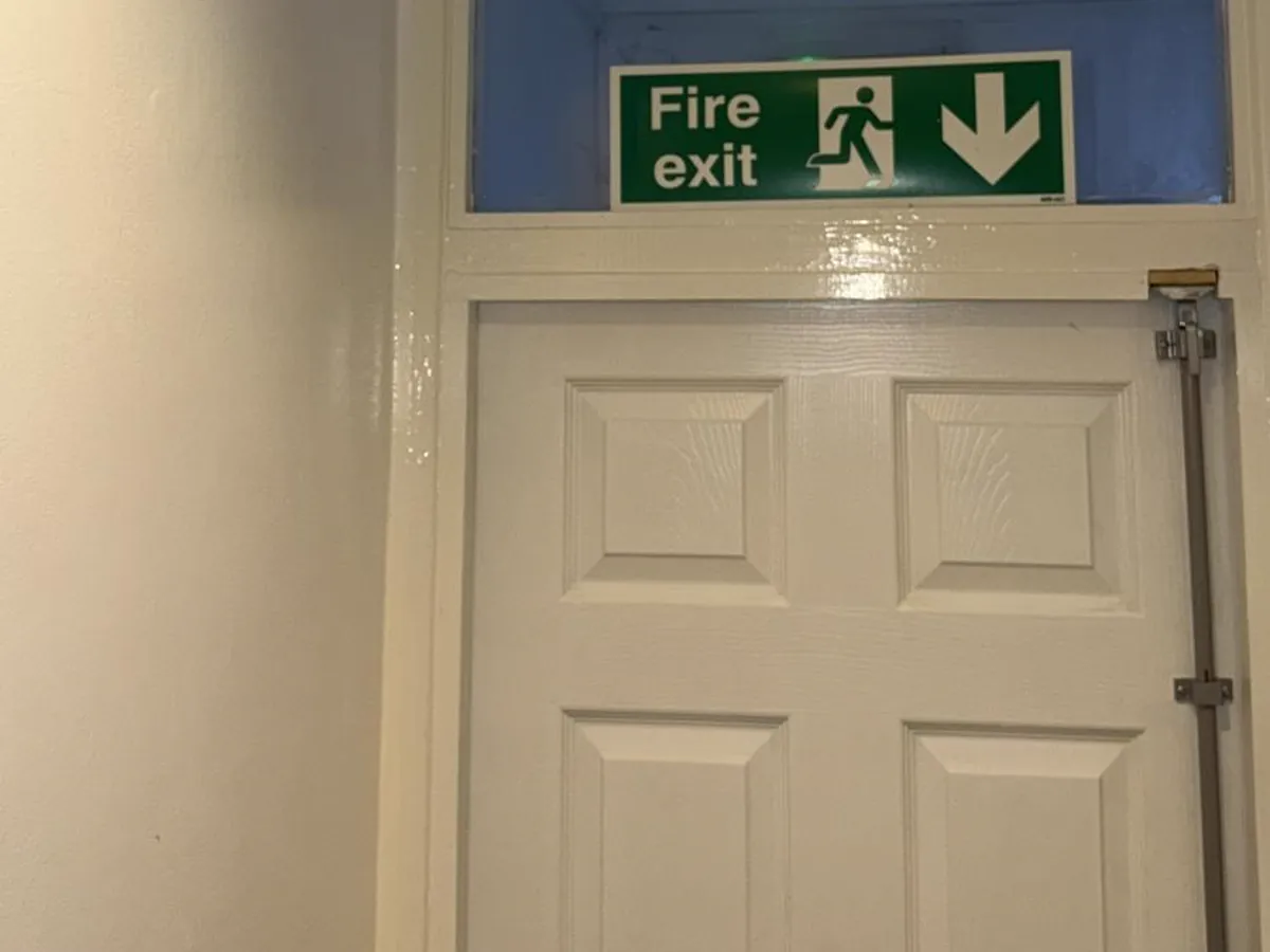 A final exit door with its fire exit sign and escape bolt, the kind of item a fire risk assessment checks