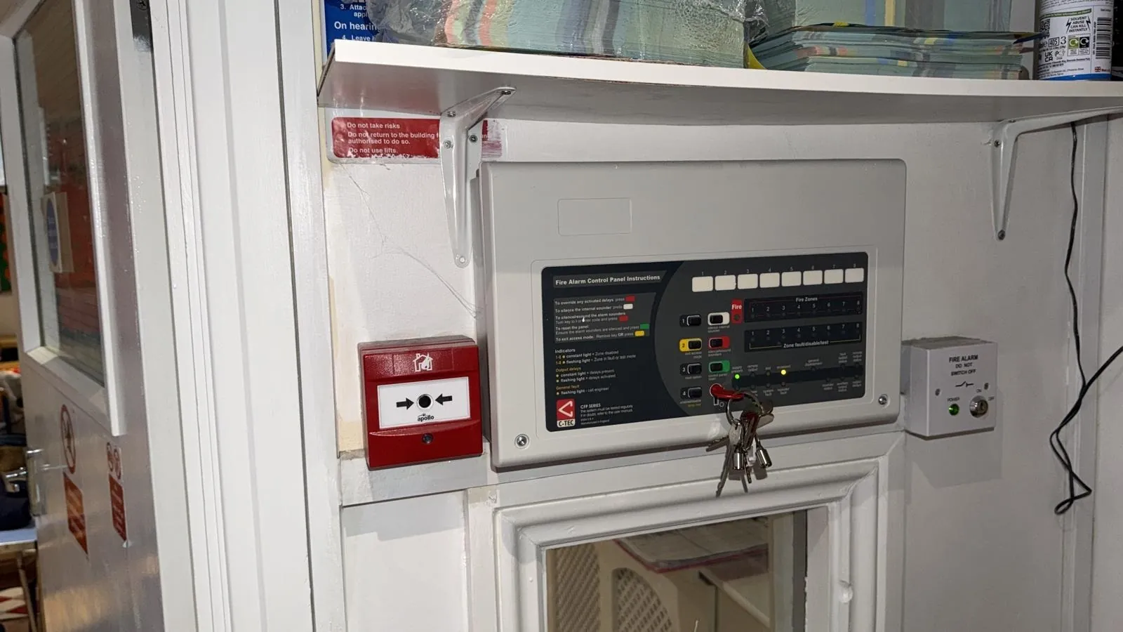 Fire alarm panel fault in London: a C-TEC conventional panel with its zone lights, a manual call point beside it and the fused spur marked do not switch off