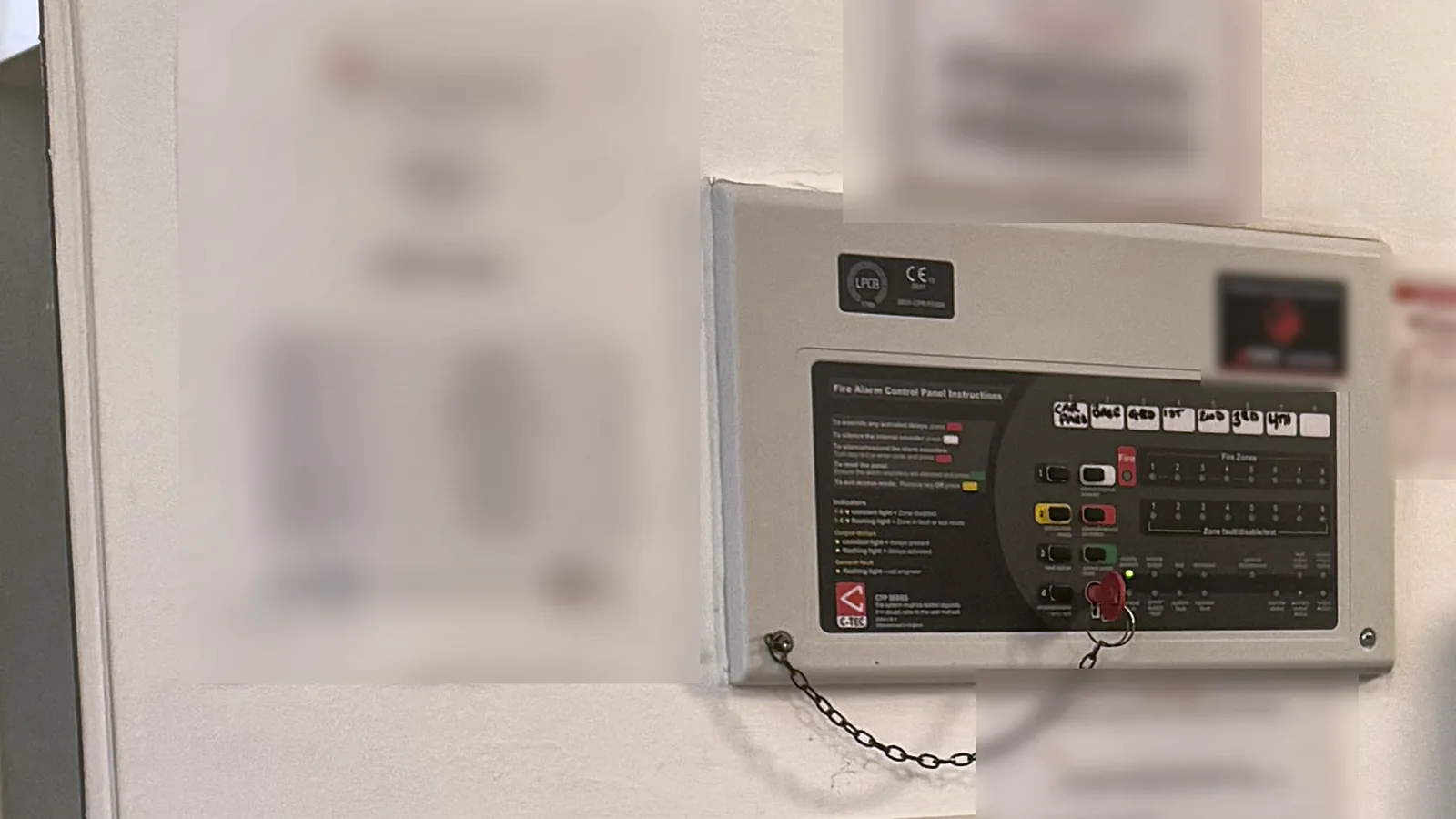 Fire alarm replacement in London: a control panel, call point and fire action notice in a communal hallway